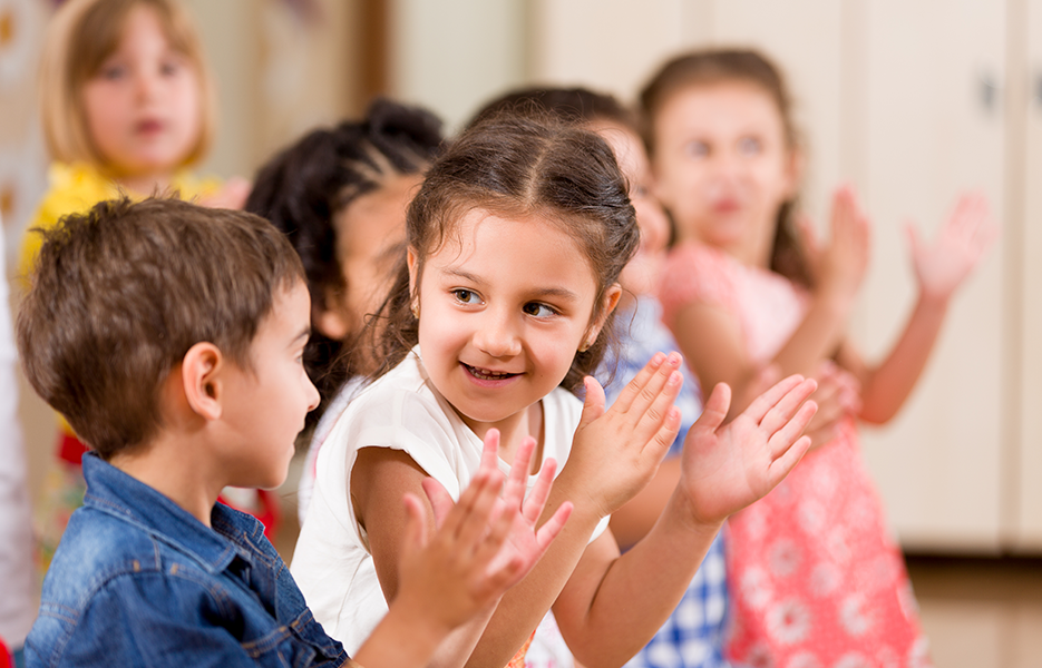 Children smiling and clapping.