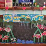 Chalkboard clipped with children self-made paper cutouts of fish.