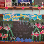 Chalkboard clipped with children self-made paper cutouts of fish.