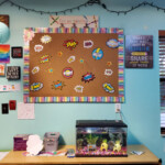 Classroom wall of a board with stickers, a desk with a fish tank.
